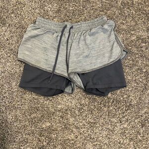 Grey athletic shorts either under tight shorts
